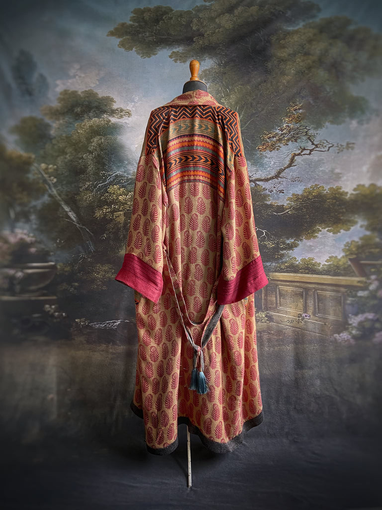 Burgundy red, sand and pumpkin orange fine wool robe with peacock motif silk lining. Wide sleeves, deep pockets and tassel sash. Unique bohemian style created from vintage and antique textiles by the Pavilion Parade studio.
