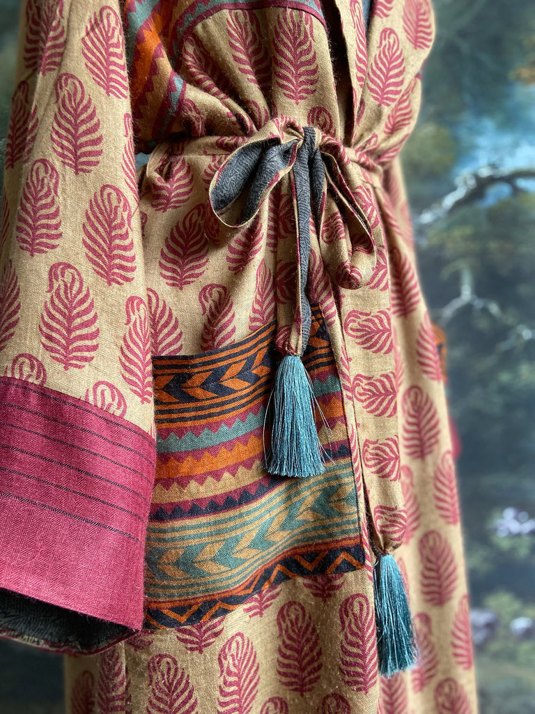 Burgundy red, sand and pumpkin orange fine wool robe with peacock motif silk lining. Wide sleeves, deep pockets and tassel sash. Unique bohemian style created from vintage and antique textiles by the Pavilion Parade studio.