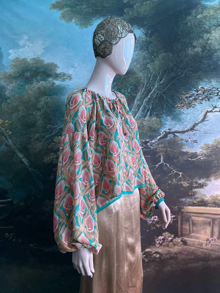 Rose pink and turquoise silk georgette Calla lily printed blouse with long full sleeves and adjustable drawstring neckline. Bohemian styles sustainably created from antique and vintage textiles by the Pavilion Parade studio. 