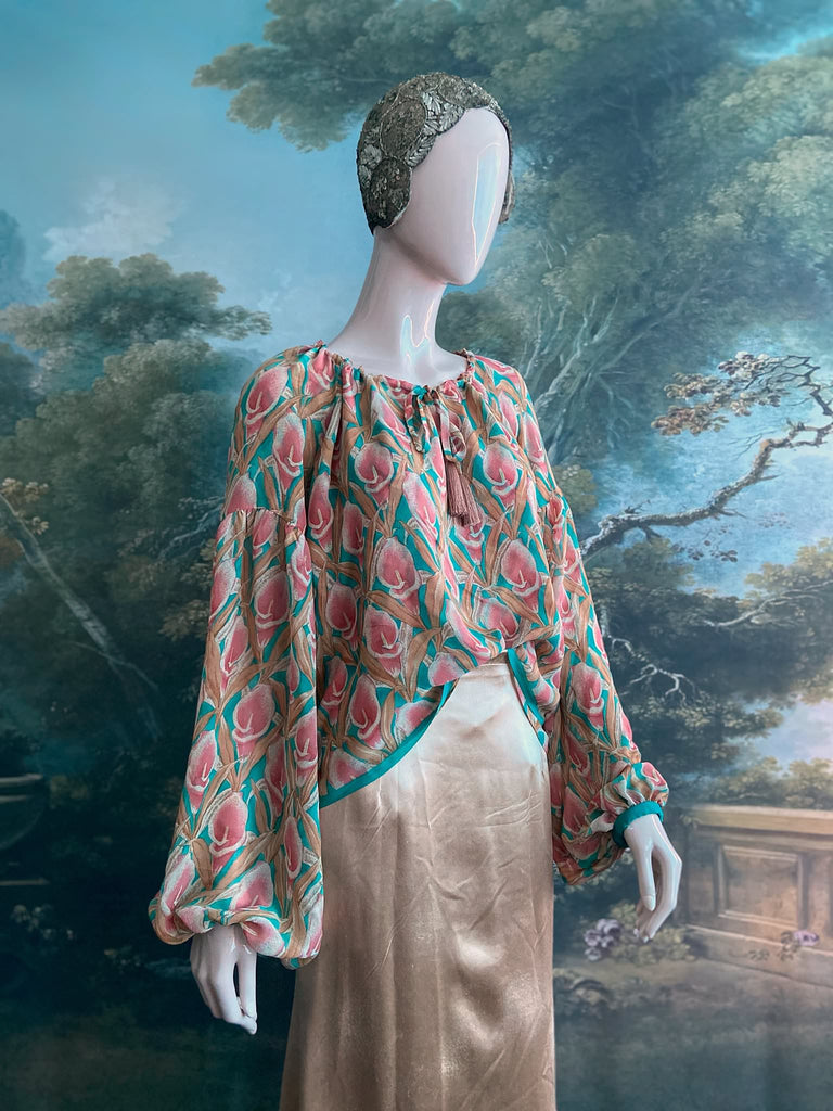 Rose pink and turquoise silk georgette Calla lily printed blouse with long full sleeves and adjustable drawstring neckline. Bohemian styles sustainably created from antique and vintage textiles by the Pavilion Parade studio. 