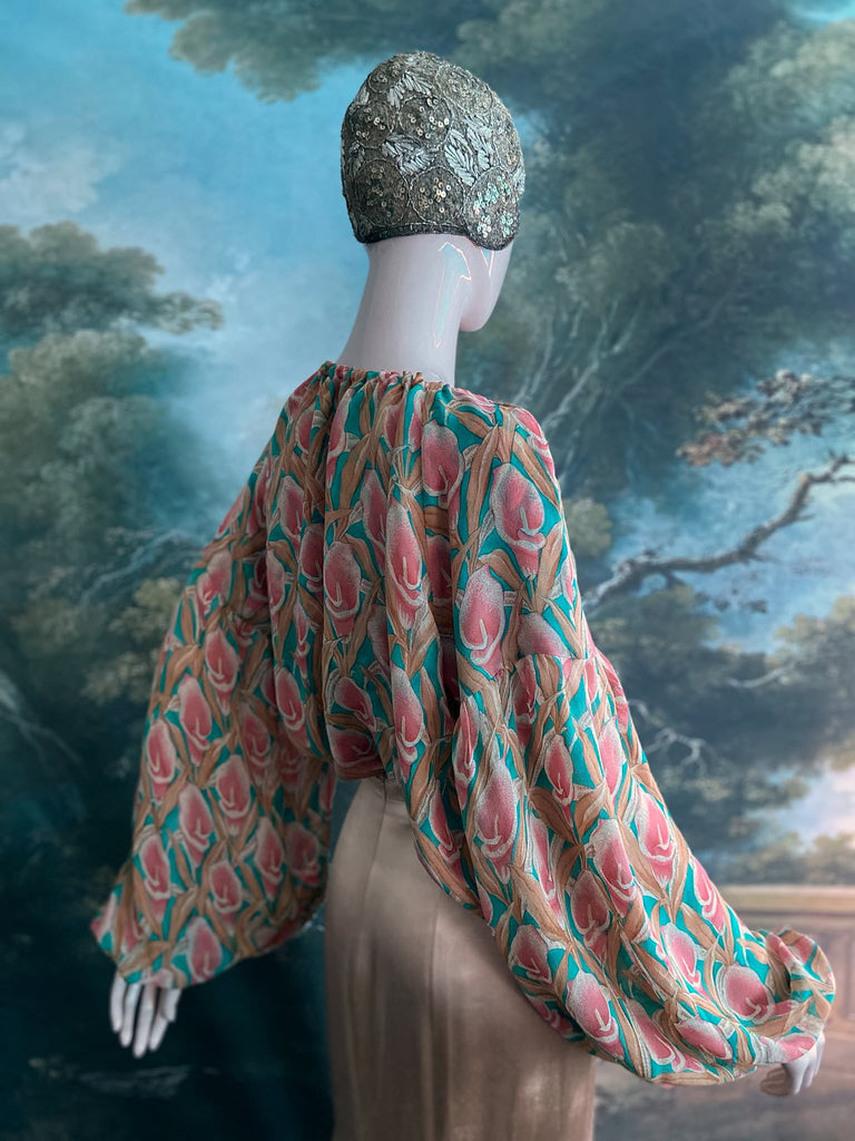 Rose pink and turquoise silk georgette Calla lily printed blouse with long full sleeves and adjustable drawstring neckline. Bohemian styles sustainably created from antique and vintage textiles by the Pavilion Parade studio. 