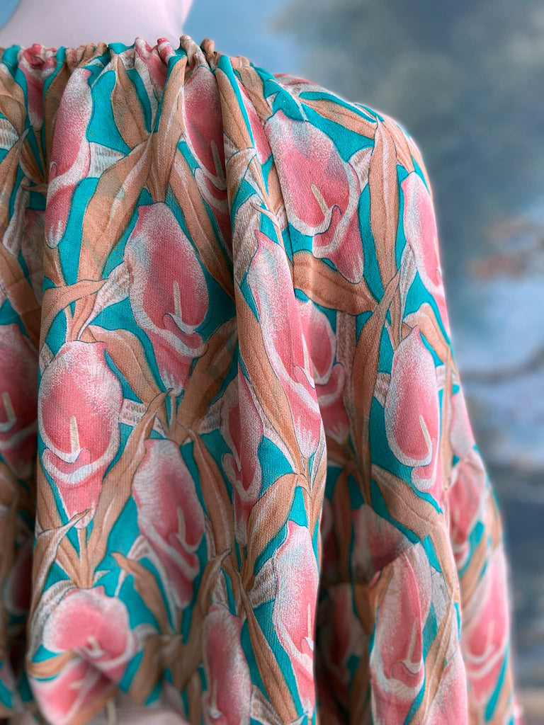 Rose pink and turquoise silk georgette Calla lily printed blouse with long full sleeves and adjustable drawstring neckline. Bohemian styles sustainably created from antique and vintage textiles by the Pavilion Parade studio. 