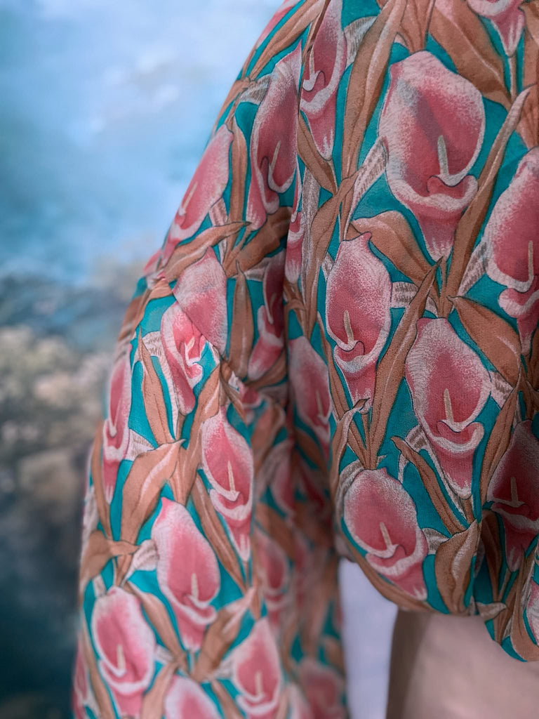 Rose pink and turquoise silk georgette Calla lily printed blouse with long full sleeves and adjustable drawstring neckline. Bohemian styles sustainably created from antique and vintage textiles by the Pavilion Parade studio. 