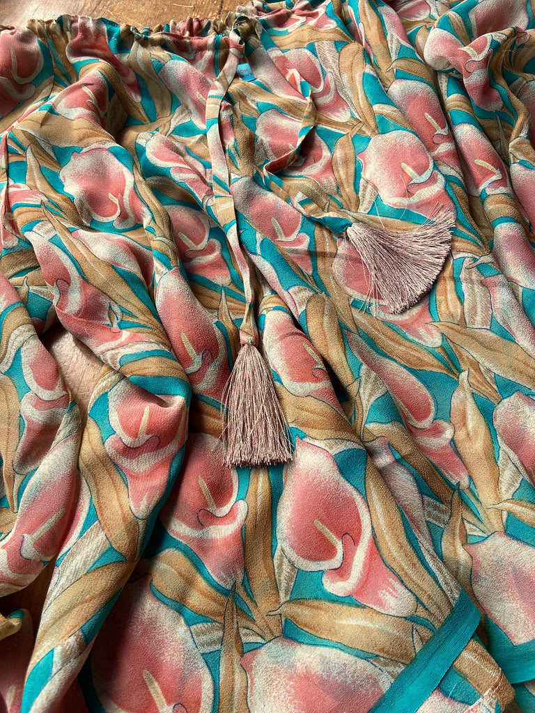 Rose pink and turquoise silk georgette Calla lily printed blouse with long full sleeves and adjustable drawstring neckline. Bohemian styles sustainably created from antique and vintage textiles by the Pavilion Parade studio. 