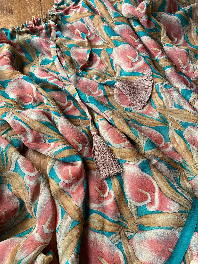 Rose pink and turquoise silk georgette Calla lily printed blouse with long full sleeves and adjustable drawstring neckline. Bohemian styles sustainably created from antique and vintage textiles by the Pavilion Parade studio. 