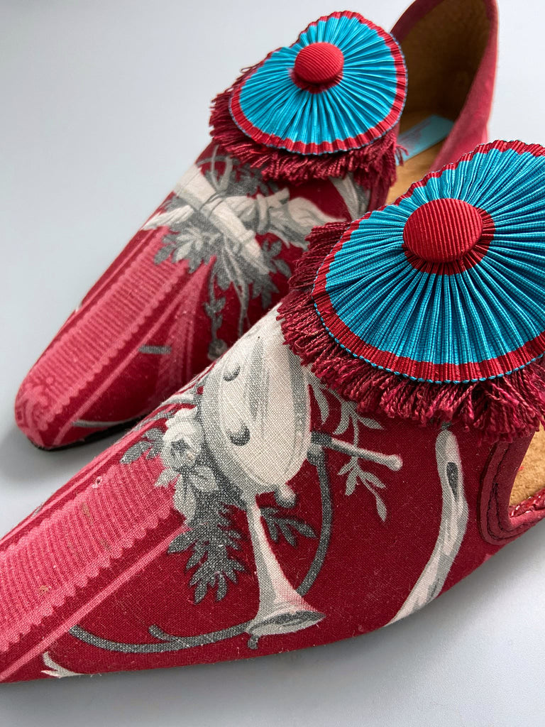 Grisaille classical motifs on crimson toile pointed toe shoes with pleated turquoise red silk ribbon embellishment. Bohemian style sustainably created from antique textiles by the Pavilion Parade studio.