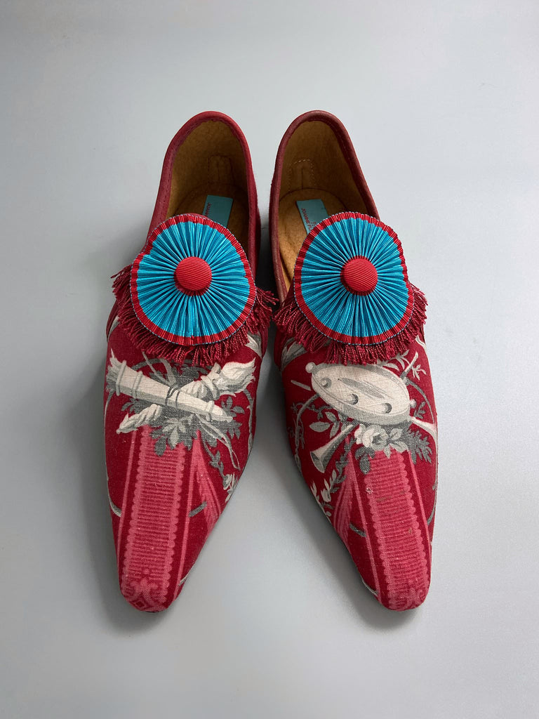 Grisaille classical motifs on crimson toile pointed toe shoes with pleated turquoise red silk ribbon embellishment. Bohemian style sustainably created from antique textiles by the Pavilion Parade studio.