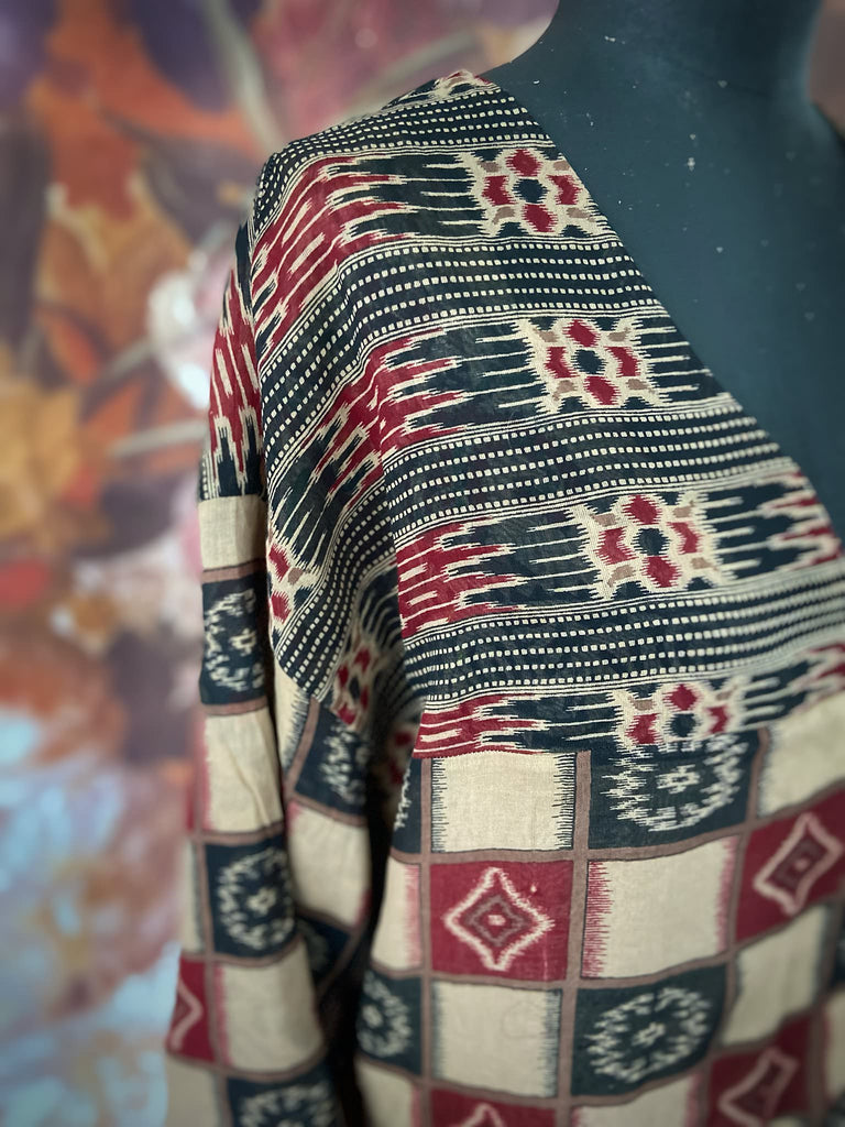 Red and black harlequin ikat print fine cotton voile kaftan dress. Fully lined, with deep pockets, wide sleeves and V neck. Bohemian styles sustainably created from antique and vintage textiles by the Pavilion Parade studio