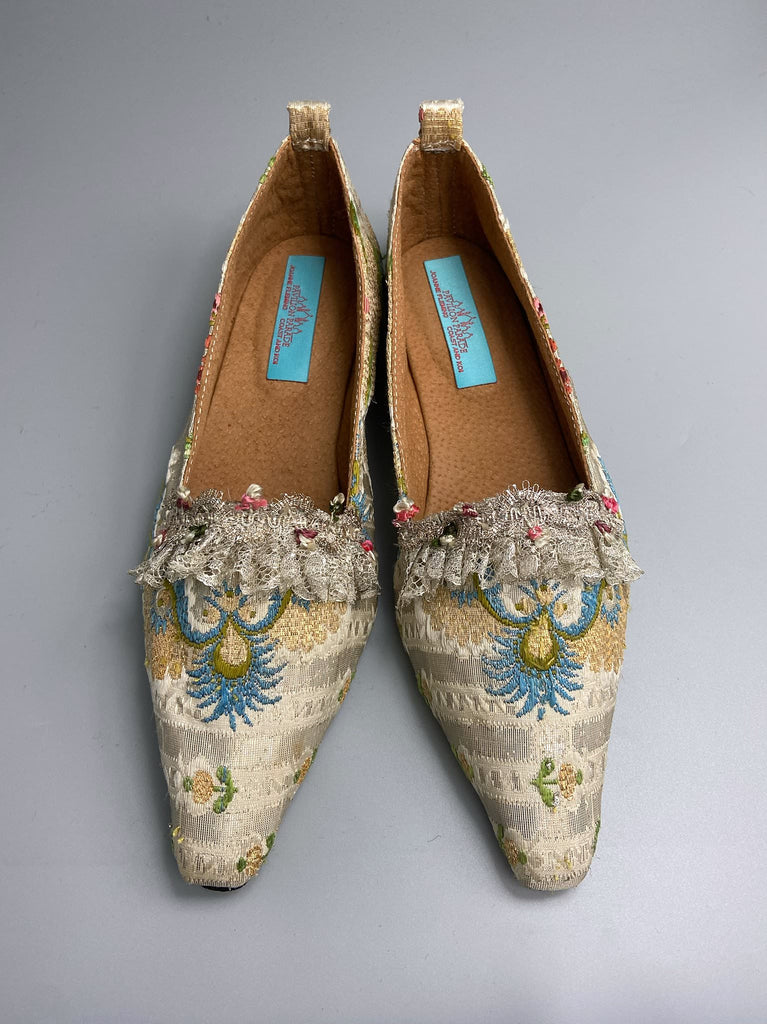 Regency dancing slipper inspired flat shoes created from an early 18th century  silk with gold and silver thread weave highlighted in cerulean blue. Embellished with rare 18th century silk floss and silver thread fly braid and  delicate antique silver lace. Bohemian style sustainably created from antique textiles by the Pavilion Parade Studio.