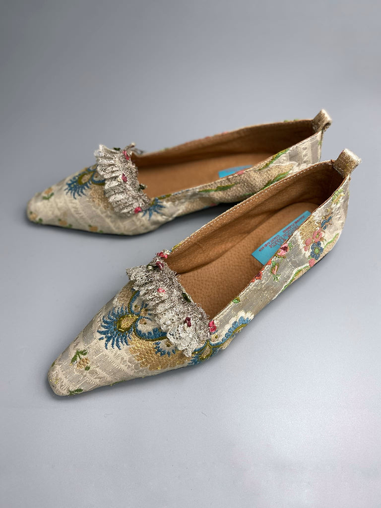 Regency dancing slipper inspired flat shoes created from an early 18th century  silk with gold and silver thread weave highlighted in cerulean blue. Embellished with rare 18th century silk floss and silver thread fly braid and  delicate antique silver lace. Bohemian style sustainably created from antique textiles by the Pavilion Parade Studio.
