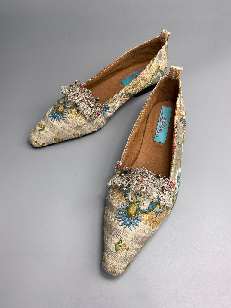 Regency dancing slipper inspired flat shoes created from an early 18th century  silk with gold and silver thread weave highlighted in cerulean blue. Embellished with rare 18th century silk floss and silver thread fly braid and  delicate antique silver lace. Bohemian style sustainably created from antique textiles by the Pavilion Parade Studio.