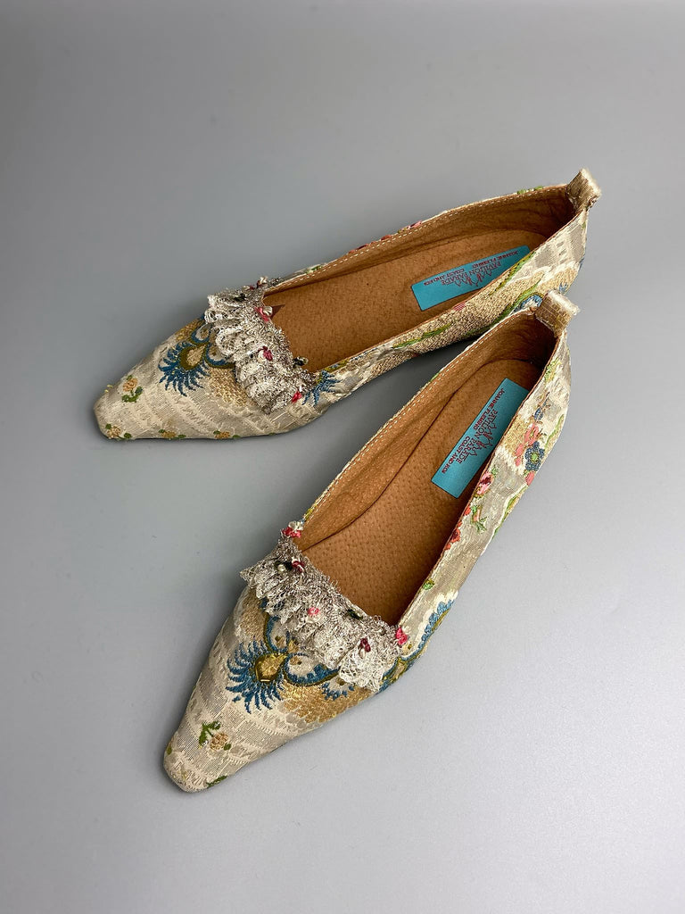 Regency dancing slipper inspired flat shoes created from an early 18th century  silk with gold and silver thread weave highlighted in cerulean blue. Embellished with rare 18th century silk floss and silver thread fly braid and  delicate antique silver lace. Bohemian style sustainably created from antique textiles by the Pavilion Parade Studio.