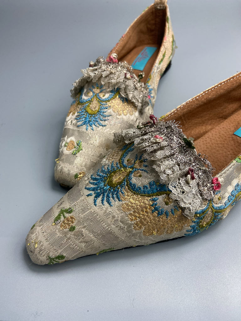 Regency dancing slipper inspired flat shoes created from an early 18th century  silk with gold and silver thread weave highlighted in cerulean blue. Embellished with rare 18th century silk floss and silver thread fly braid and  delicate antique silver lace. Bohemian style sustainably created from antique textiles by the Pavilion Parade Studio.