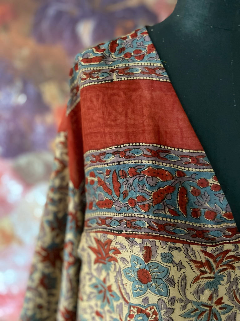Reversible block printed kalamkari cotton kaftan dress. Slate blue and rust Indienne paisley and floral motif. Deep pockets, wide sleeves and a relaxed fit. Bohemian style created from vintage and antique textiles by the Pavilion Parade studio.