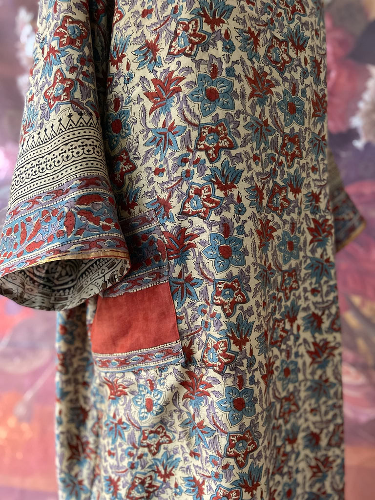 Reversible block printed kalamkari cotton kaftan dress. Slate blue and rust Indienne paisley and floral motif. Deep pockets, wide sleeves and a relaxed fit. Bohemian style created from vintage and antique textiles by the Pavilion Parade studio.