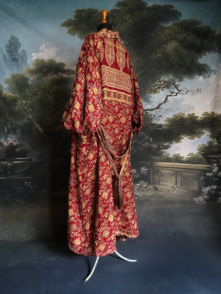 Reversible red and golden yellow cotton kalamkari and voile robe with balloon sleeves, side pockets, and tassel sash. Bohemian style sustainably created from vintage textiles by the Pavilion Parade Studio