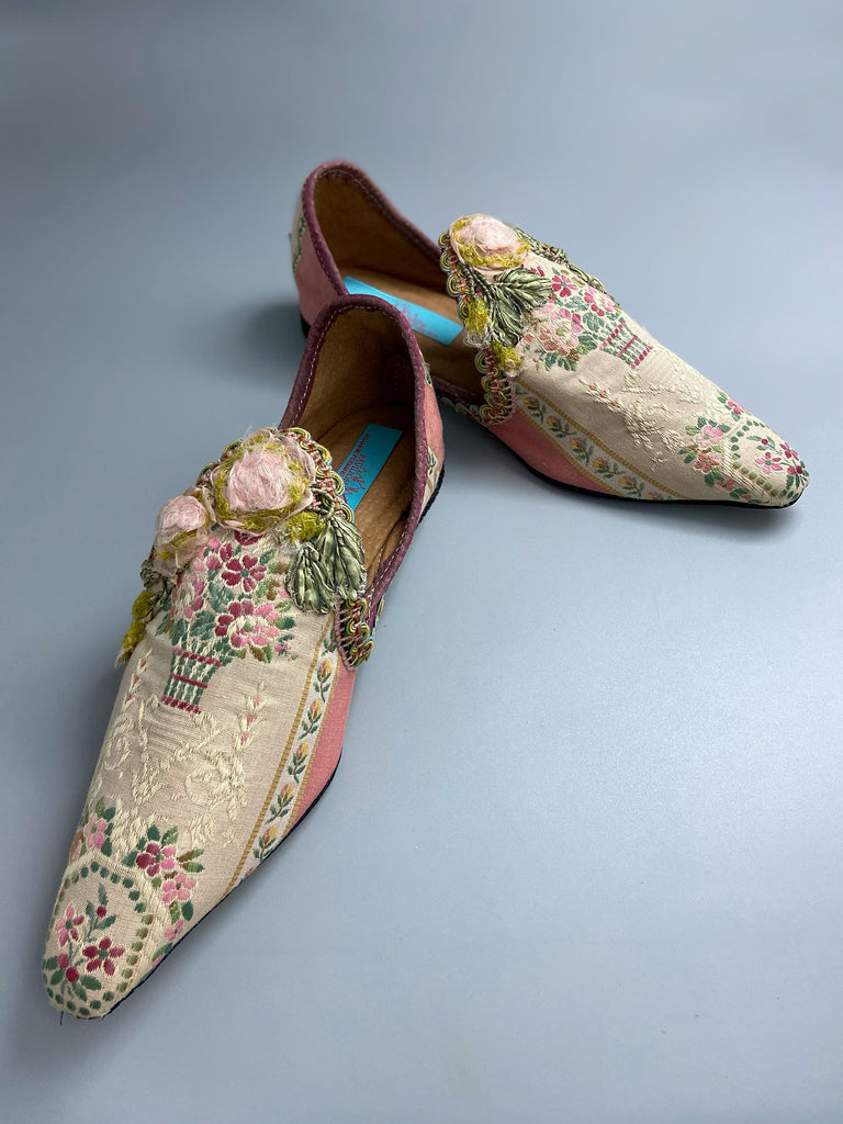 Dusty pink and cream silk pointed toe shoes with timeworn ribbon roses in the Georgian style. Embellished with antique braids. Bohemian styles sustainably created from antique textiles by Pavilion Parade.
