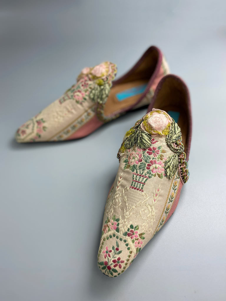 Dusty pink and cream silk pointed toe shoes with timeworn ribbon roses in the Georgian style. Embellished with antique braids. Bohemian styles sustainably created from antique textiles by Pavilion Parade.