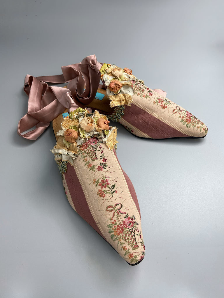 Mauve pink and cream silk pointed toe shoes with antique C18th pinked dress trim and timeworn ribbon roses in the Georgian style. Embellished with antique braids. Bohemian styles sustainably created from antique textiles by Pavilion Parade.