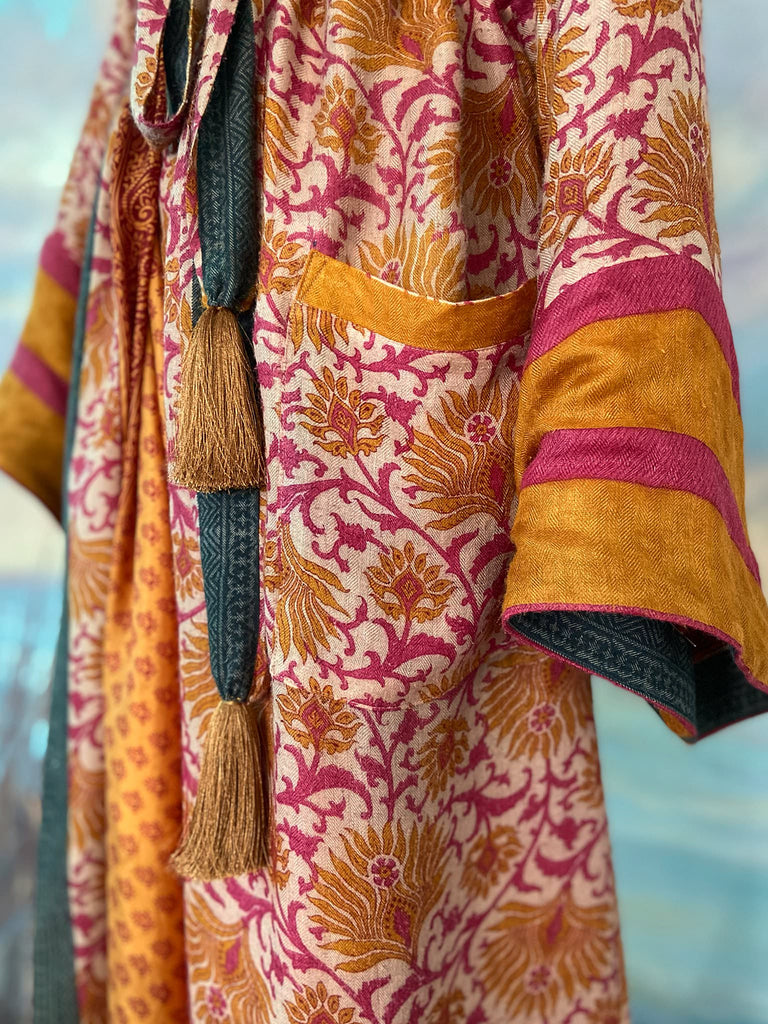 Saffron and hot pink fine wool dressing robe lined with silk. Wide sleeves, patch pockets and tassel sash belt. Bohemian styles sustainably created from antique and vintage textiles by the Pavilion Parade studio.