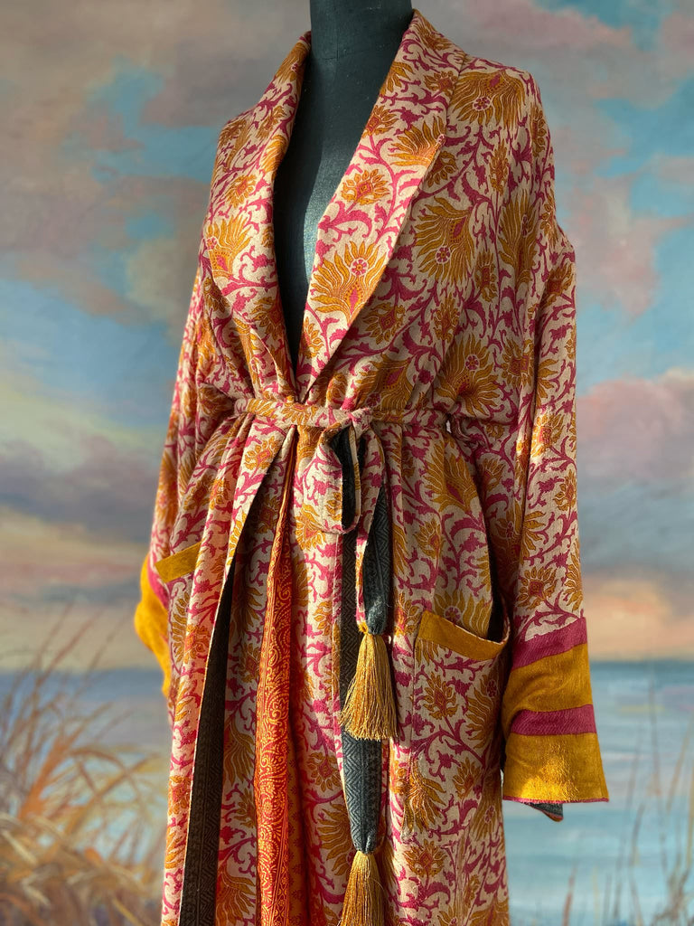 Saffron and hot pink fine wool dressing robe lined with silk. Wide sleeves, patch pockets and tassel sash belt. Bohemian styles sustainably created from antique and vintage textiles by the Pavilion Parade studio.