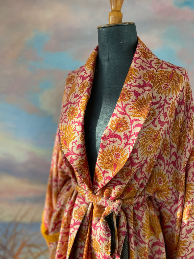 Saffron and hot pink fine wool dressing robe lined with silk. Wide sleeves, patch pockets and tassel sash belt. Bohemian styles sustainably created from antique and vintage textiles by the Pavilion Parade studio.