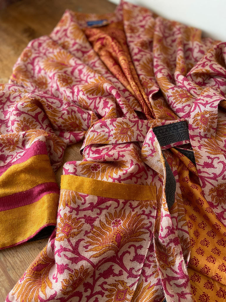 Saffron and hot pink fine wool dressing robe lined with silk. Wide sleeves, patch pockets and tassel sash belt. Bohemian styles sustainably created from antique and vintage textiles by the Pavilion Parade studio.