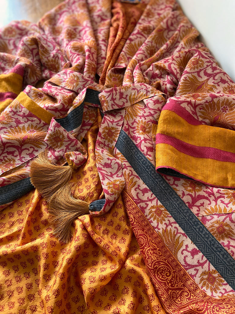 Saffron and hot pink fine wool dressing robe lined with silk. Wide sleeves, patch pockets and tassel sash belt. Bohemian styles sustainably created from antique and vintage textiles by the Pavilion Parade studio.