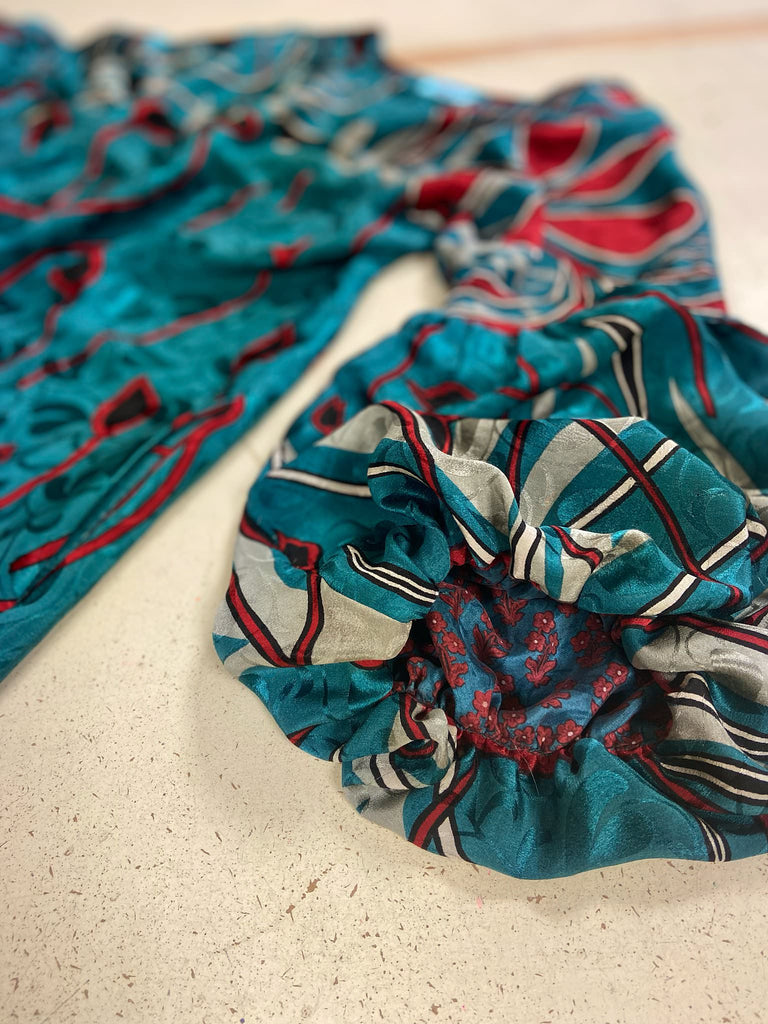 Relaxed fit silk crepe shift dress with full gathered long sleeves, scoop neck and pockets. Teal green with a bold print in black, red, and white. Sustainably created from vintage and antique textiles by the Pavilion Parade studio.