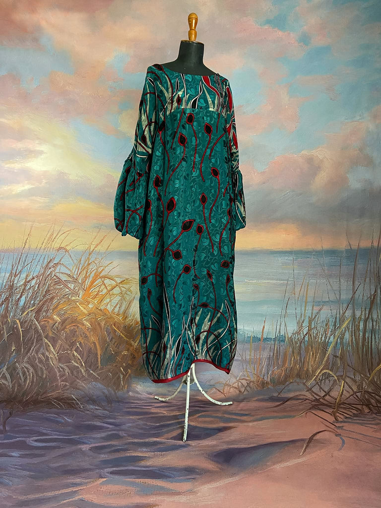 Relaxed fit silk crepe shift dress with full gathered long sleeves, scoop neck and pockets. Teal green with a bold print in black, red, and white. Sustainably created from vintage and antique textiles by the Pavilion Parade studio.
