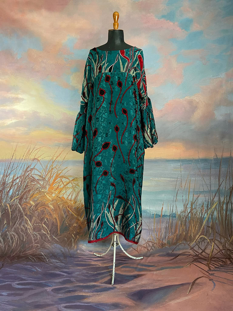 Relaxed fit silk crepe shift dress with full gathered long sleeves, scoop neck and pockets. Teal green with a bold print in black, red, and white. Sustainably created from vintage and antique textiles by the Pavilion Parade studio.