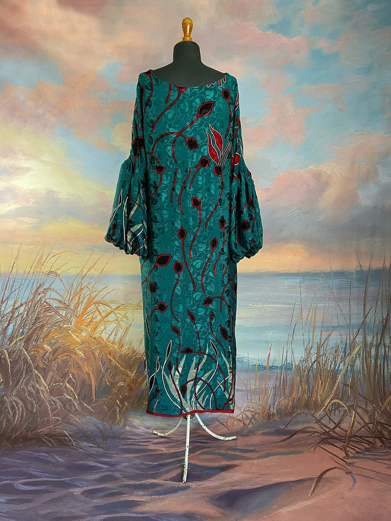 Relaxed fit silk crepe shift dress with full gathered long sleeves, scoop neck and pockets. Teal green with a bold print in black, red, and white. Sustainably created from vintage and antique textiles by the Pavilion Parade studio.
