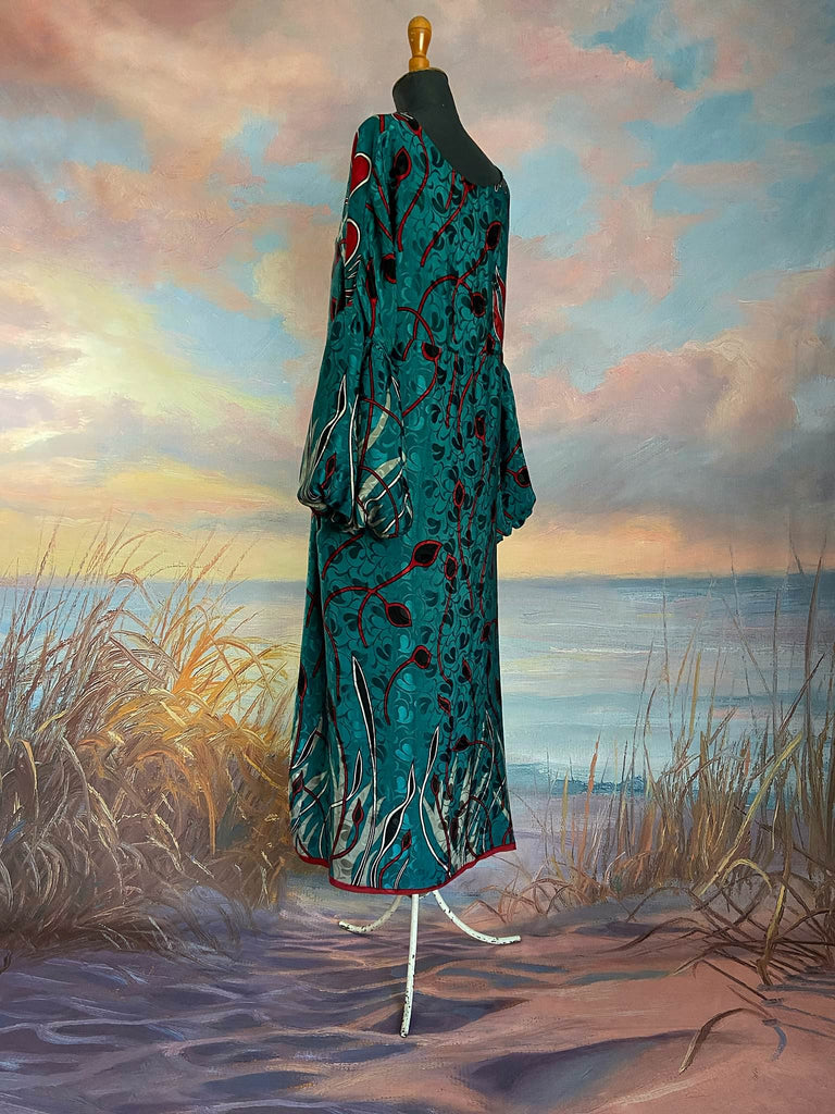 Relaxed fit silk crepe shift dress with full gathered long sleeves, scoop neck and pockets. Teal green with a bold print in black, red, and white. Sustainably created from vintage and antique textiles by the Pavilion Parade studio.