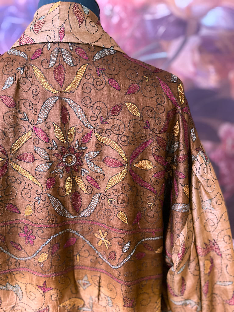 Toffee and caramel hand embroidered kantha silk robe with full sleeves, oversize pockets and tassel sash. Fully lined in silk, and sustainably created from antique and vintage textiles by the Pavilion Parade studio.