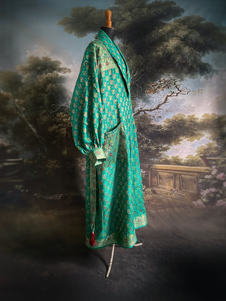 Turquoise green light silk brocade wrapper robe with full sleeves, large patch pockets and tassel sash. Bohemian style sustainably created from antique and vintage textiles by the Pavilion Parade studio.
