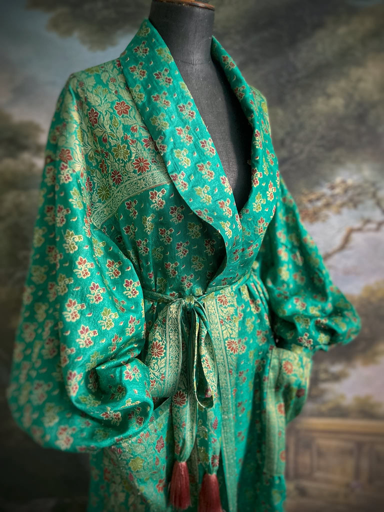 Turquoise green light silk brocade wrapper robe with full sleeves, large patch pockets and tassel sash. Bohemian style sustainably created from antique and vintage textiles by the Pavilion Parade studio.