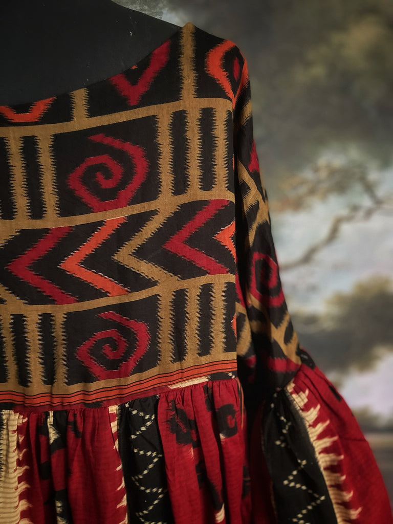 Artistic Dress inspired scarlet and black ikat printed Indian cotton muslin dress  with balloon sleeves, pockets, and integral tiered petticoat. Bohemian style sustainably created from vintage and antique textiles by the Pavilion Parade studio. 