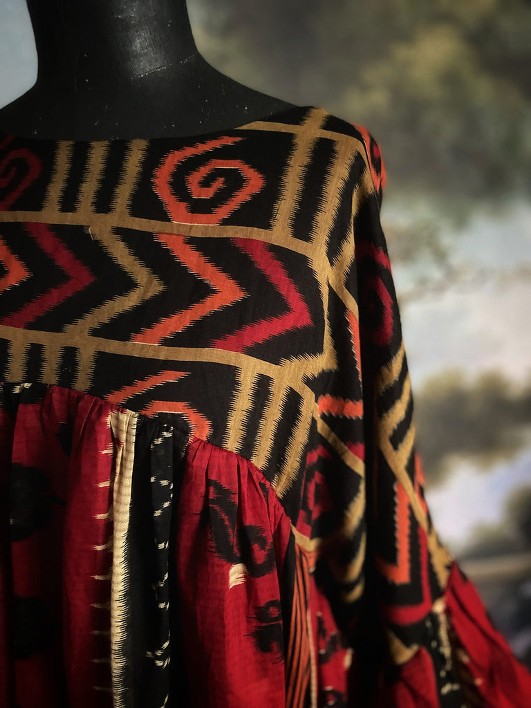 Artistic Dress inspired scarlet and black ikat printed Indian cotton muslin dress  with balloon sleeves, pockets, and integral tiered petticoat. Bohemian style sustainably created from vintage and antique textiles by the Pavilion Parade studio. 