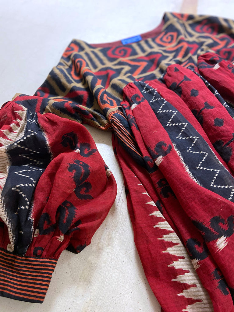 Artistic Dress inspired scarlet and black ikat printed Indian cotton muslin dress  with balloon sleeves, pockets, and integral tiered petticoat. Bohemian style sustainably created from vintage and antique textiles by the Pavilion Parade studio. 