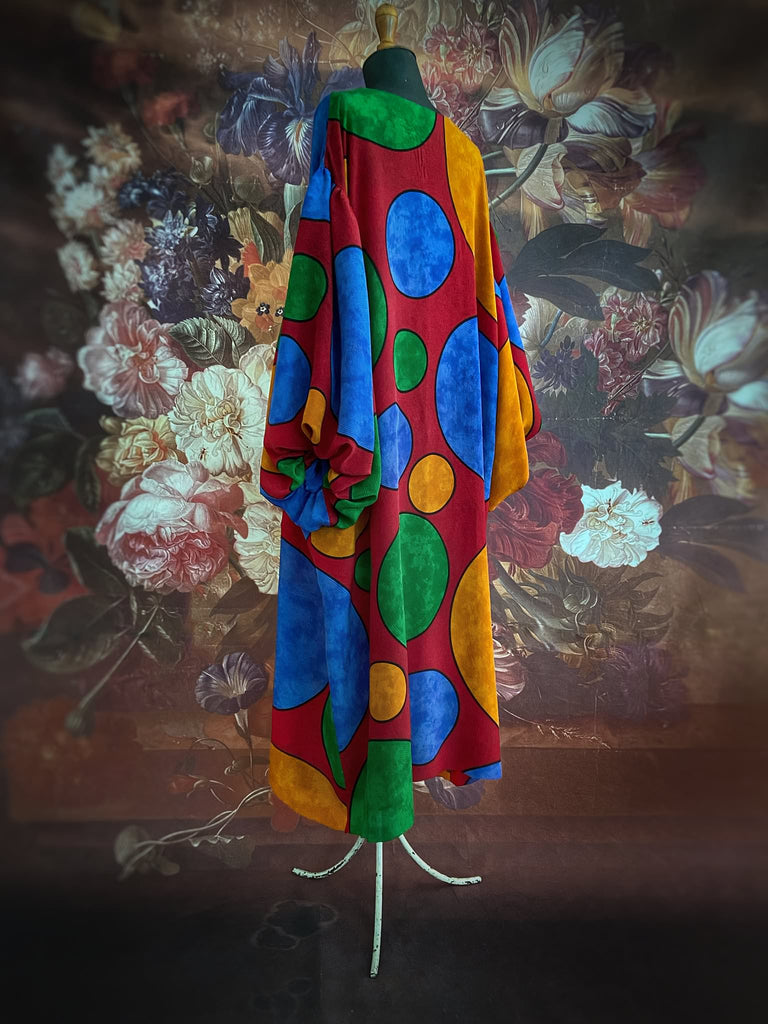 Vibrant silk crepe relaxed fit dress with full balloon sleeves, V neck and pockets. Printed design of giant oversize polka dot spots. Bohemian style created from antique and vintage textiles by the Pavilion Parade studio.