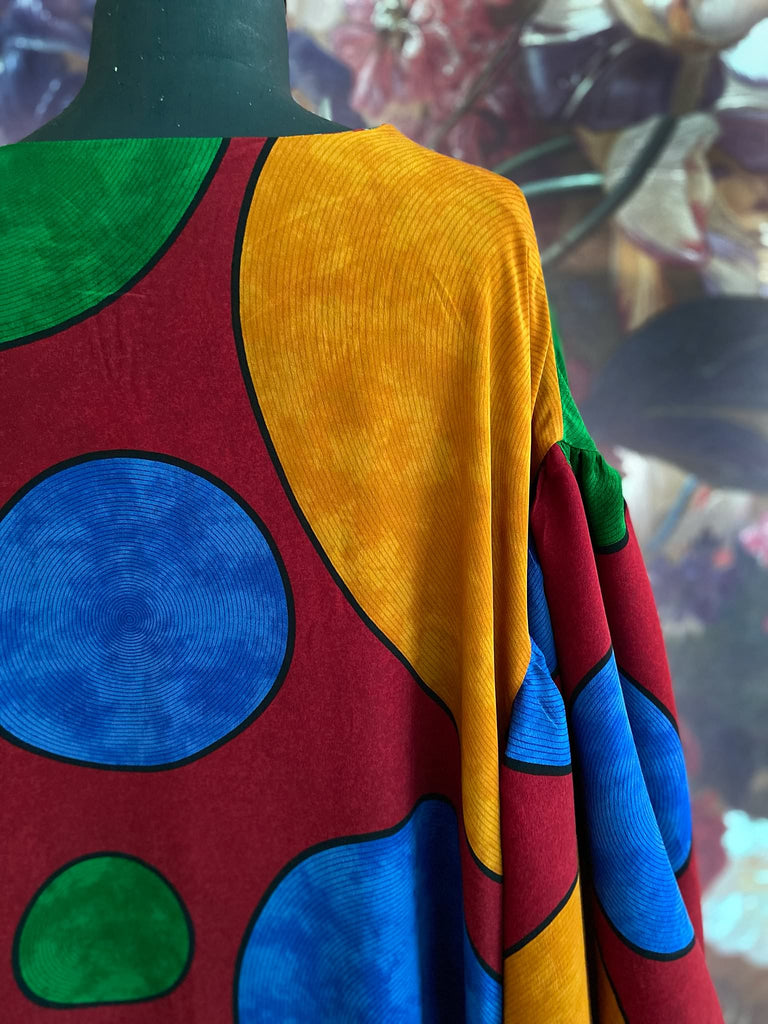 Vibrant silk crepe relaxed fit dress with full balloon sleeves, V neck and pockets. Printed design of giant oversize polka dot spots. Bohemian style created from antique and vintage textiles by the Pavilion Parade studio.