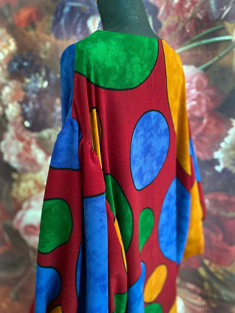 Vibrant silk crepe relaxed fit dress with full balloon sleeves, V neck and pockets. Printed design of giant oversize polka dot spots. Bohemian style created from antique and vintage textiles by the Pavilion Parade studio.