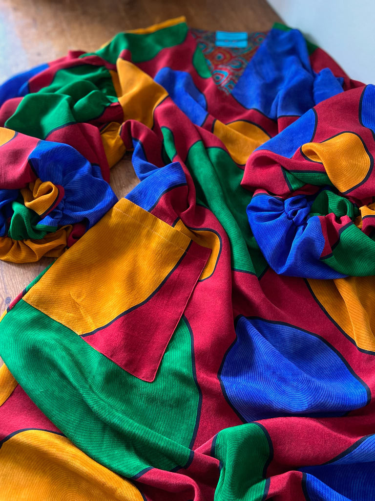 Vibrant silk crepe relaxed fit dress with full balloon sleeves, V neck and pockets. Printed design of giant oversize polka dot spots. Bohemian style created from antique and vintage textiles by the Pavilion Parade studio.