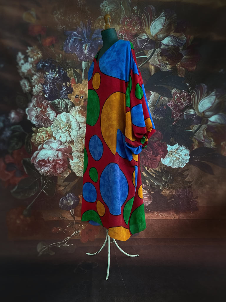 Vibrant silk crepe relaxed fit dress with full balloon sleeves, V neck and pockets. Printed design of giant oversize polka dot spots. Bohemian style created from antique and vintage textiles by the Pavilion Parade studio.