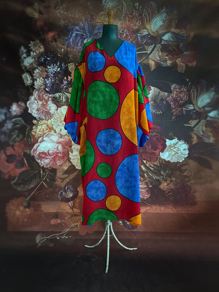 Vibrant silk crepe relaxed fit dress with full balloon sleeves, V neck and pockets. Printed design of giant oversize polka dot spots. Bohemian style created from antique and vintage textiles by the Pavilion Parade studio.