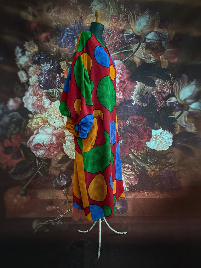 Vibrant silk crepe relaxed fit dress with full balloon sleeves, V neck and pockets. Printed design of giant oversize polka dot spots. Bohemian style created from antique and vintage textiles by the Pavilion Parade studio.
