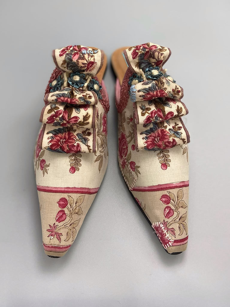 Pompadour Marie Antoinette inspired shoes created from antique early 1800s rose pink and ivory block printed French cotton toile and embellished in blue silk passementerie rosettes. Bohemian style from the Pavilion Parade studio.