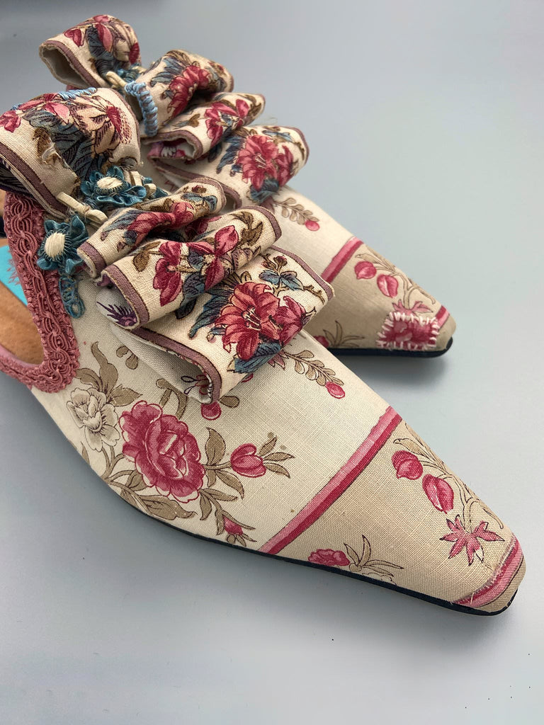 Pompadour Marie Antoinette inspired shoes created from antique early 1800s rose pink and ivory block printed French cotton toile and embellished in blue silk passementerie rosettes. Bohemian style from the Pavilion Parade studio.