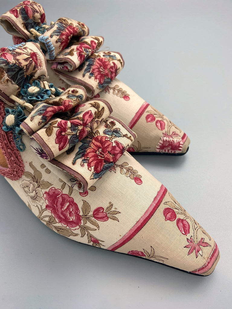 Pompadour Marie Antoinette inspired shoes created from antique early 1800s rose pink and ivory block printed French cotton toile and embellished in blue silk passementerie rosettes. Bohemian style from the Pavilion Parade studio.