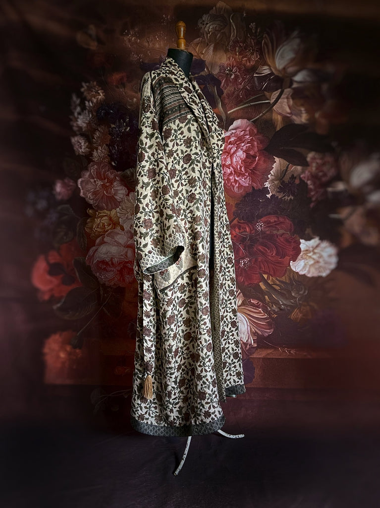 Chestnut brown and olive green fine wool dressing robe or duster coat with a design of Indienne florals. Wide sleeves, deep pockets, tassel sash. Lined in printed silk. Sustainably created from antique and vintage textiles by the Pavilion Parade studio.